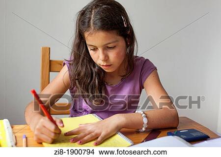 Young girl working hard on her schoolwork View Large Photo Image Picture - Young girl working hard on her schoolwork. Fotosearch