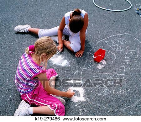 Stock Photograph - Young girls drawing on pavement with chalk. Anacortes, Skagit County. Washington, USA. Fotosearch