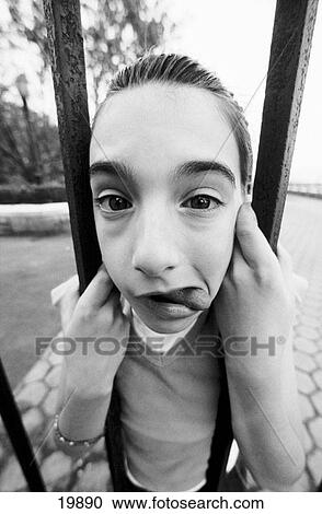 Young girl's face caught in bars View Large Photo Image Stock Image - Young girl's face caught in bars. Fotosearch