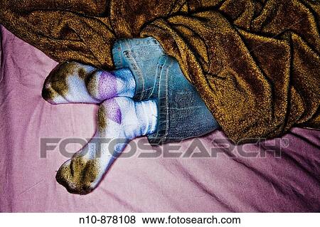 Stock Photo - Young girl's feet sticking out from under her blanket.. Fotosearch