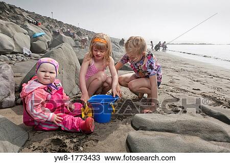 Stock Image - Young girls playing at the beach, Akranes, Iceland. Fotosearch