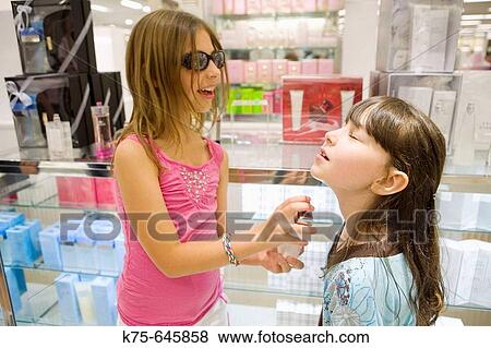 young girls testing perfume at cosmetic counter View Large Photo Image Stock Photo - young girls testing perfume at cosmetic counter. Fotosearch