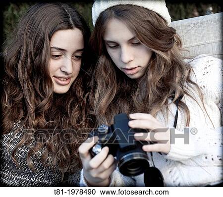 Stock Image - Young girls using camera. Fotosearch