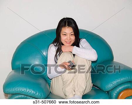 Young good looking asian girl watching TV View Large Photo Image Stock Image - Young good looking asian girl watching TV. Fotosearch