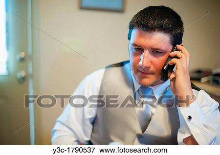 Young groom making phone call while getting ready for his wedding Caucasian, 19 years View Large Photo Image Stock Photo - Young groom making phone call while getting ready for his wedding Caucasian, 19 years. Fotosearch