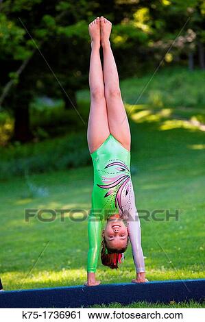 Young gymnast doing handstand on balance beam View Large Photo Image Stock Image - Young gymnast doing handstand on balance beam. Fotosearch