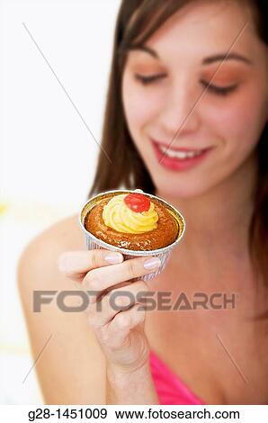 Young happy woman holding a cream cake View Large Photo Image Stock Photo - Young happy woman holding a cream cake. Fotosearch