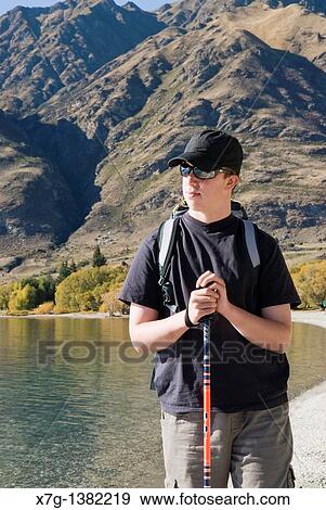 Stock Photo - Young hiker resting at Glendhu Bay on the shores of Lake Wanaka, South Island of New Zealand. Fotosearch