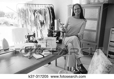 Stock Photography - Young hispanic fashion designer starting up her business in her home garage. Fotosearch