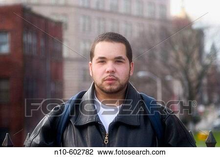 Young Hispanic man standing on a city street. View Large Photo Image Stock Image - Young Hispanic man standing on a city street.. Fotosearch