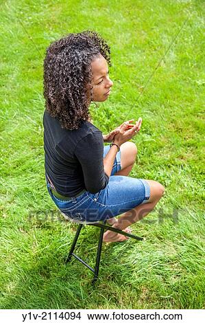 Young Hispanic woman in a park. View Large Photo Image Picture - Young Hispanic woman in a park.. Fotosearch