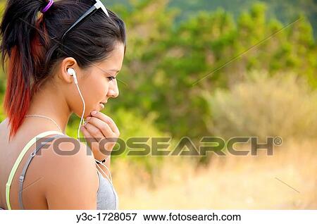 Young hispanic woman listening to music on her mp3 player View Large Photo Image Stock Photo - Young hispanic woman listening to music on her mp3 player. Fotosearch