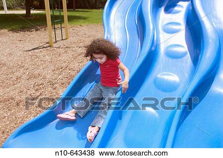 Young Hispanic/Italian girl playing on a slide at a playground. View Large Photo Image Stock Photo - Young Hispanic/Italian girl playing on a slide at a playground.. Fotosearch