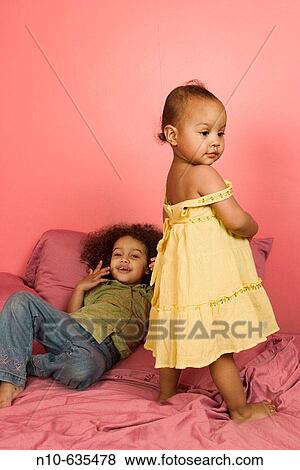 Young Hispanic/Italian sisters playing on their bed View Large Photo Image Stock Photo - Young Hispanic/Italian sisters playing on their bed. Fotosearch