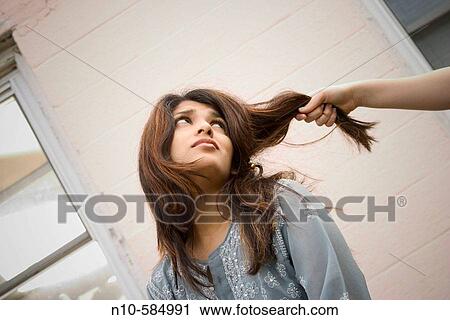 Young Indian woman's hair being pulled by her preteen Caucasian stepsister. View Large Photo Image Stock Image - Young Indian woman's hair being pulled by her preteen Caucasian stepsister.. Fotosearch