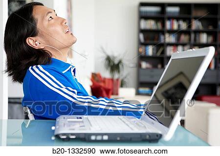 Young Japanese man with laptop computer in room View Large Photo Image Stock Image - Young Japanese man with laptop computer in room. Fotosearch
