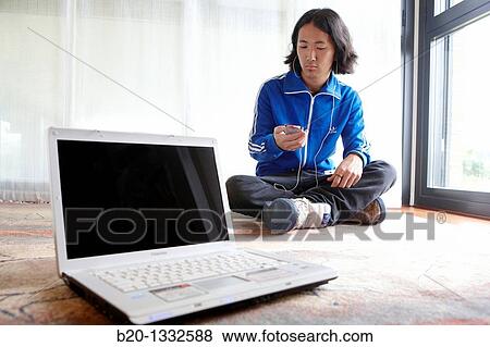 Young Japanese man with laptop computer in room View Large Photo Image Stock Photo - Young Japanese man with laptop computer in room. Fotosearch