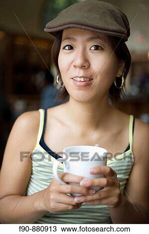 Stock Image - Young Japanese woman in coffeeshop. Fotosearch
