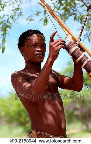 Young Jo/? hoansi San man putting his hunting gear together, Namibia, Africa. View Large Photo Image Picture - Young Jo/? hoansi San man putting his hunting gear together, Namibia, Africa.. Fotosearch