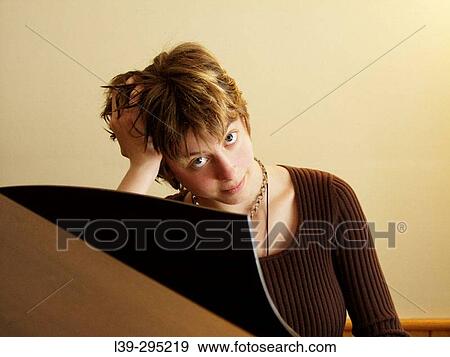 Stock Photo - Young lady at her piano. Fotosearch