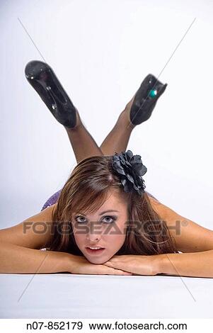 Stock Photo - Young lady lying showing her shoes. Fotosearch