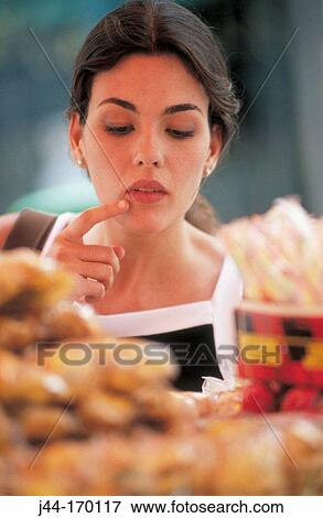 Young latin woman at a food stand in the street View Large Photo Image Stock Photo - Young latin woman at a food stand in the street. Fotosearch
