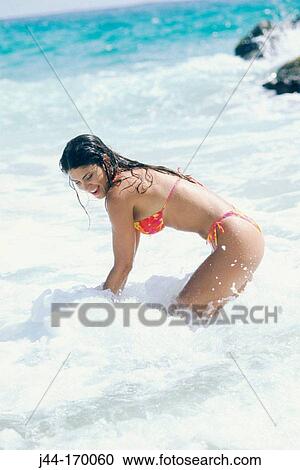 Stock Image - Young latin woman in the water at the beach, Venezuela. Fotosearch