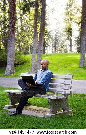 Stock Photo - Young male in the park buisness. Fotosearch