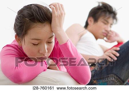 Young Man and Woman sitting depressed on sofa. View Large Photo Image Stock Image - Young Man and Woman sitting depressed on sofa.. Fotosearch
