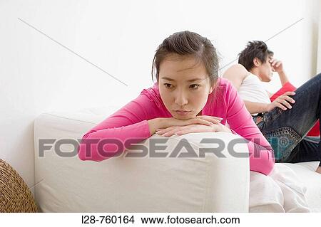 Picture - Young Man and Woman sitting Sadness on sofa.. Fotosearch
