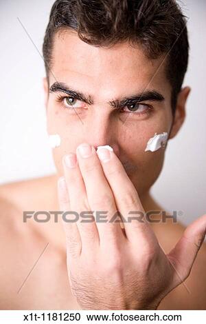 Young man applying facial cream. View Large Photo Image Stock Image - Young man applying facial cream.. Fotosearch