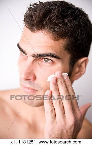 Young man applying facial cream. View Large Photo Image Stock Image - Young man applying facial cream.. Fotosearch