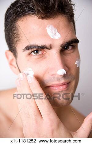 Young man applying facial cream. View Large Photo Image Stock Image - Young man applying facial cream.. Fotosearch
