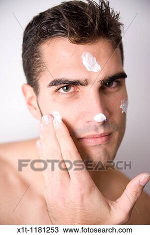 Young man applying facial cream. View Large Photo Image Stock Image - Young man applying facial cream.. Fotosearch