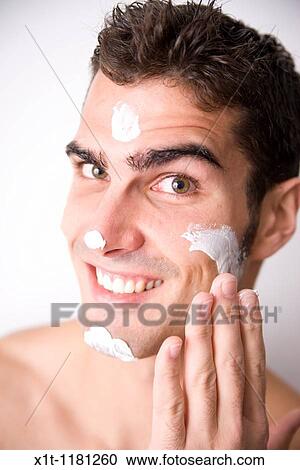 Young man applying facial cream. View Large Photo Image Stock Image - Young man applying facial cream.. Fotosearch