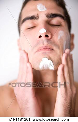 Young man applying facial cream. View Large Photo Image Stock Image - Young man applying facial cream.. Fotosearch