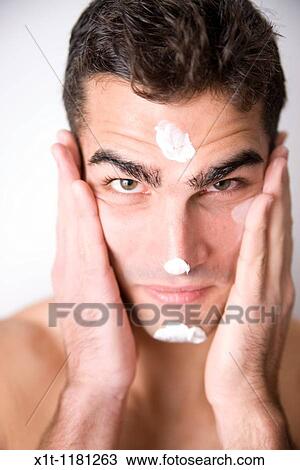 Young man applying facial cream. View Large Photo Image Stock Image - Young man applying facial cream.. Fotosearch