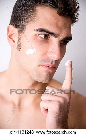 Young man applying facial cream. View Large Photo Image Stock Photo - Young man applying facial cream.. Fotosearch