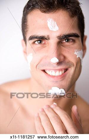Young man applying facial cream. View Large Photo Image Stock Photo - Young man applying facial cream.. Fotosearch