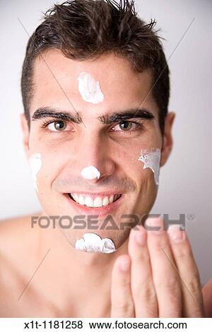 Young man applying facial cream. View Large Photo Image Stock Photo - Young man applying facial cream.. Fotosearch