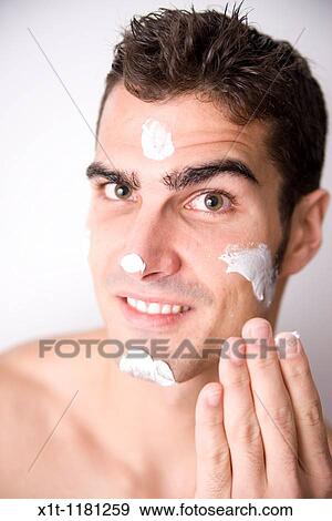 Young man applying facial cream. View Large Photo Image Stock Photo - Young man applying facial cream.. Fotosearch