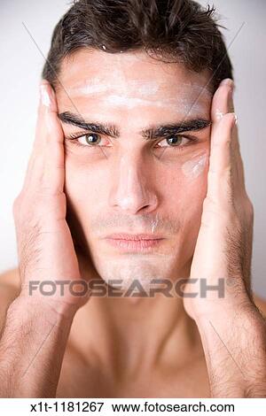Young man applying facial cream. View Large Photo Image Stock Photo - Young man applying facial cream.. Fotosearch