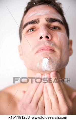 Young man applying facial cream. View Large Photo Image Stock Photograph - Young man applying facial cream.. Fotosearch