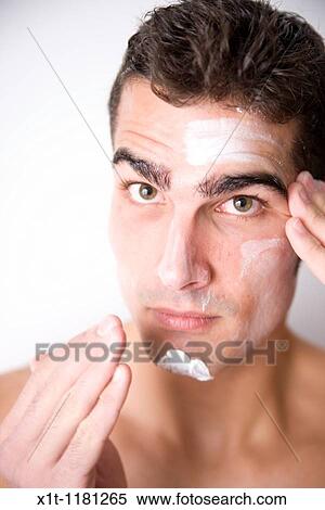 Young man applying facial cream. View Large Photo Image Stock Photography - Young man applying facial cream.. Fotosearch
