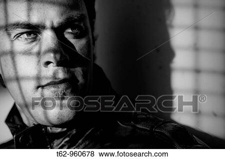 Stock Photo - Young man behind bars Black and white Conceptual. Fotosearch