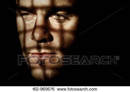 Stock Photograph - Young man behind bars Color Conceptual. Fotosearch