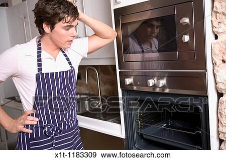 Stock Photo - Young man cooking. Fotosearch