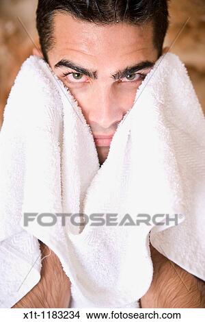 Picture - Young man drying his face.. Fotosearch