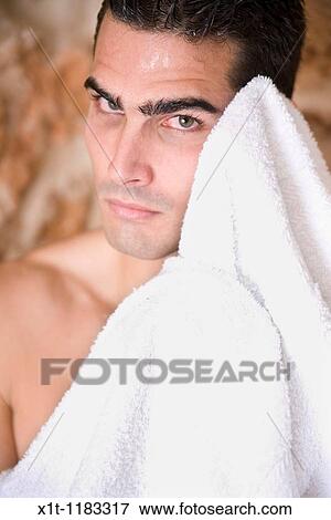 Stock Photo - Young man drying his face.. Fotosearch