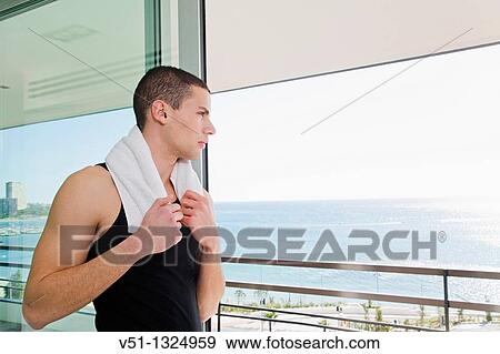 Stock Photo - Young man enjoyning the views and looking at the sea and horizon. Fotosearch